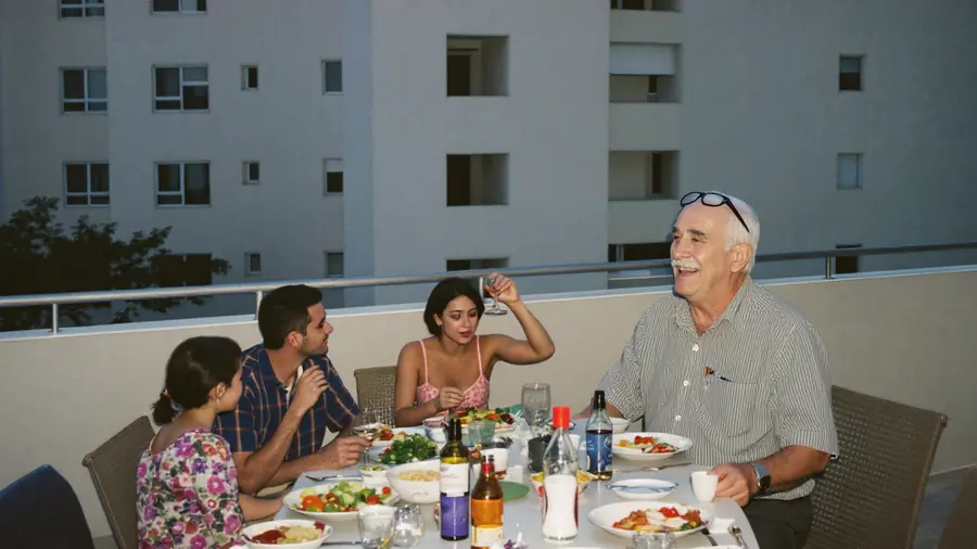 ארוחה משפחתית במרפסת, אבא צוחק בראש השולחן